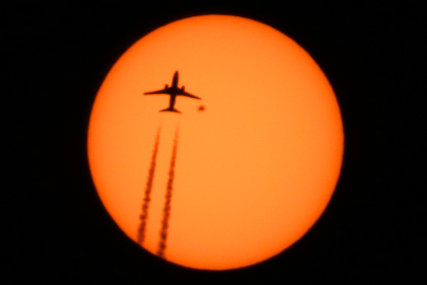 Airplane Boeing 737 flight WestJet 2773 from Port of Spain Trinidad and Tobago  to Toronto Canada passing in front of the Sun with sunspot AR2529 high above Manhattan, New York on April 13, 2016 photo Alexander Krivenyshev WorldTimeZone